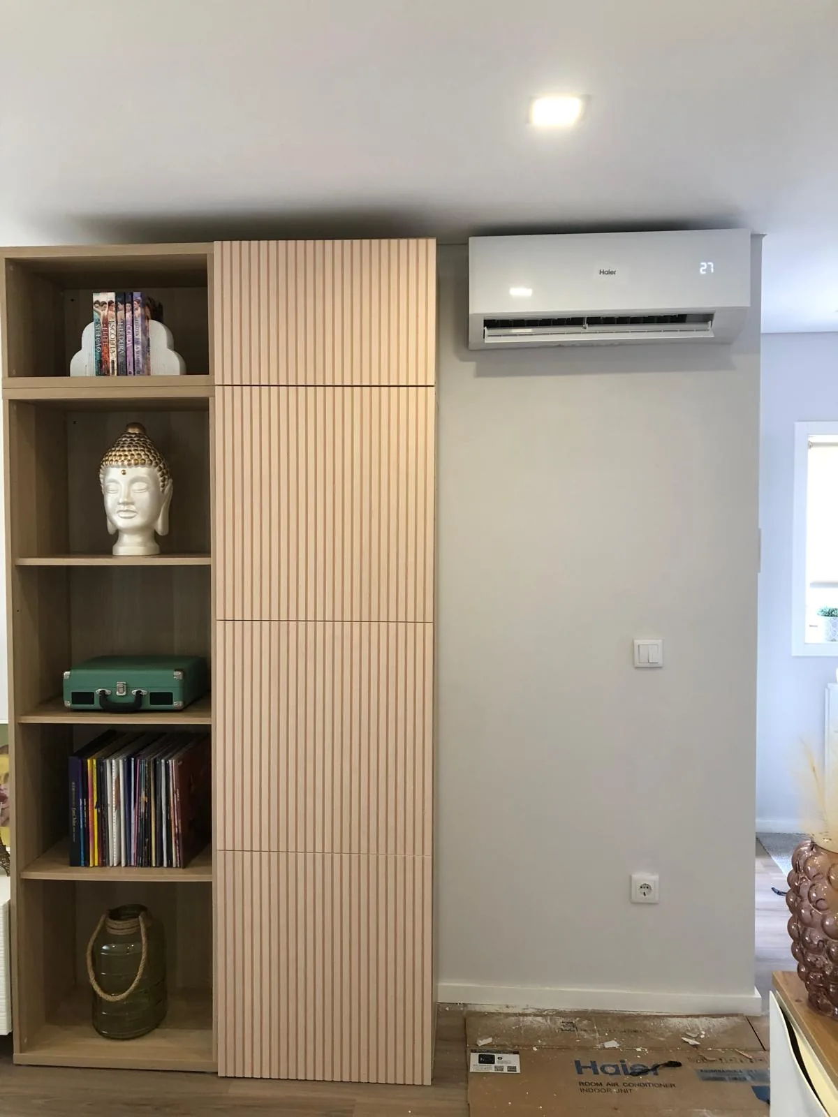 Sala com estante, revestimento em madeira e ar condicionado